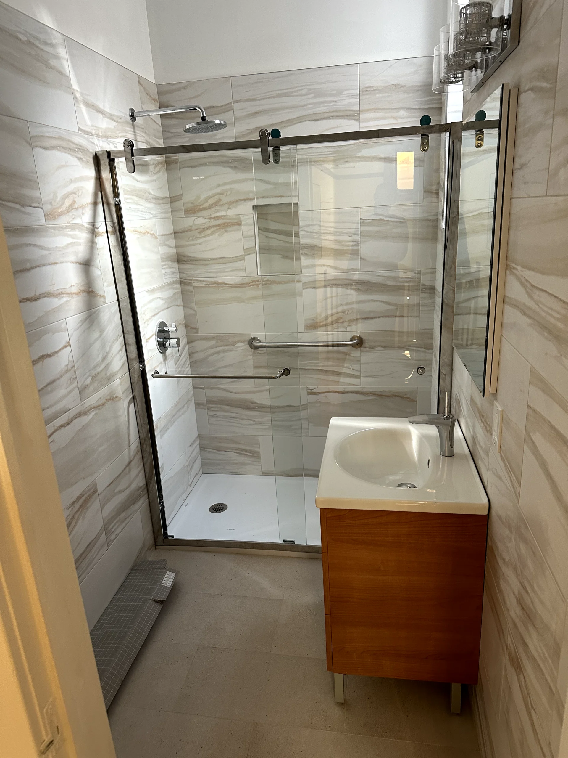 Bathroom remodel installation in Sacramento with new shower walls, vanity, flooring, and fixture updates in progress.