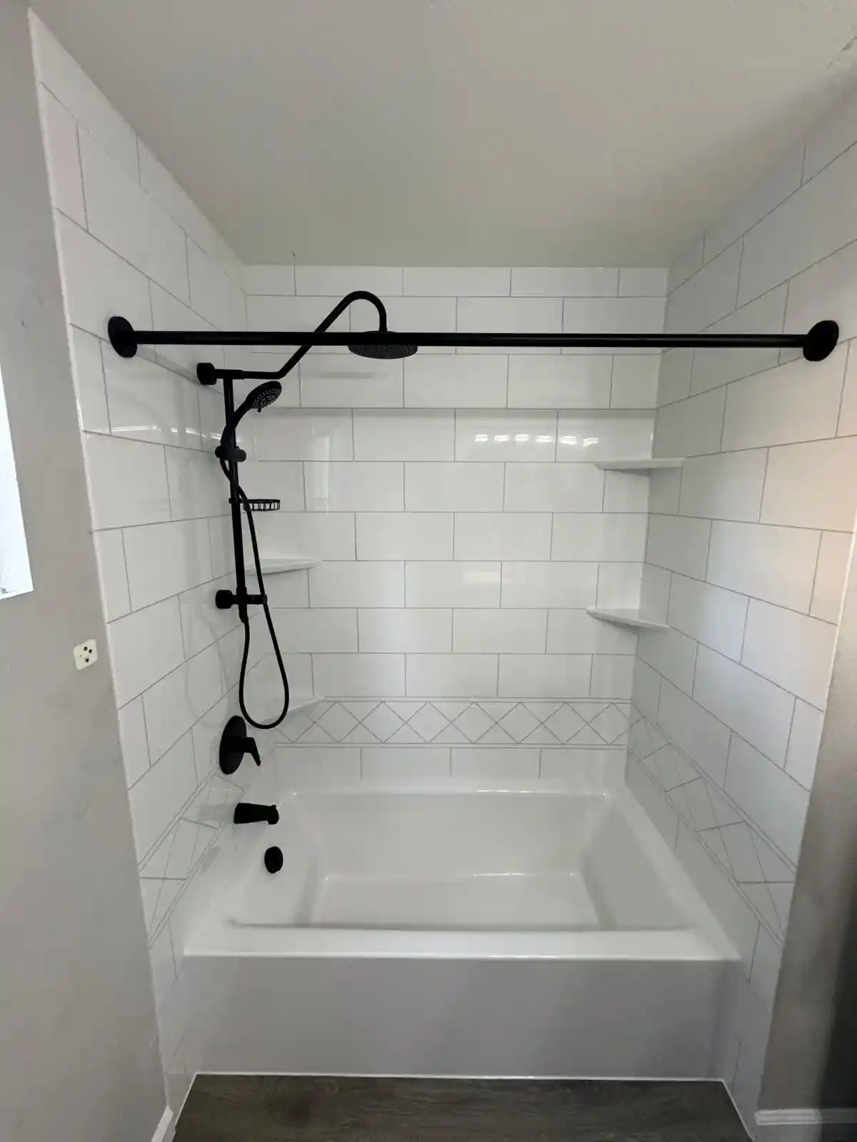 Tub and shower remodel in Folsom with white subway tile, black shower fixtures, rainfall shower head, and built-in corner shelves.