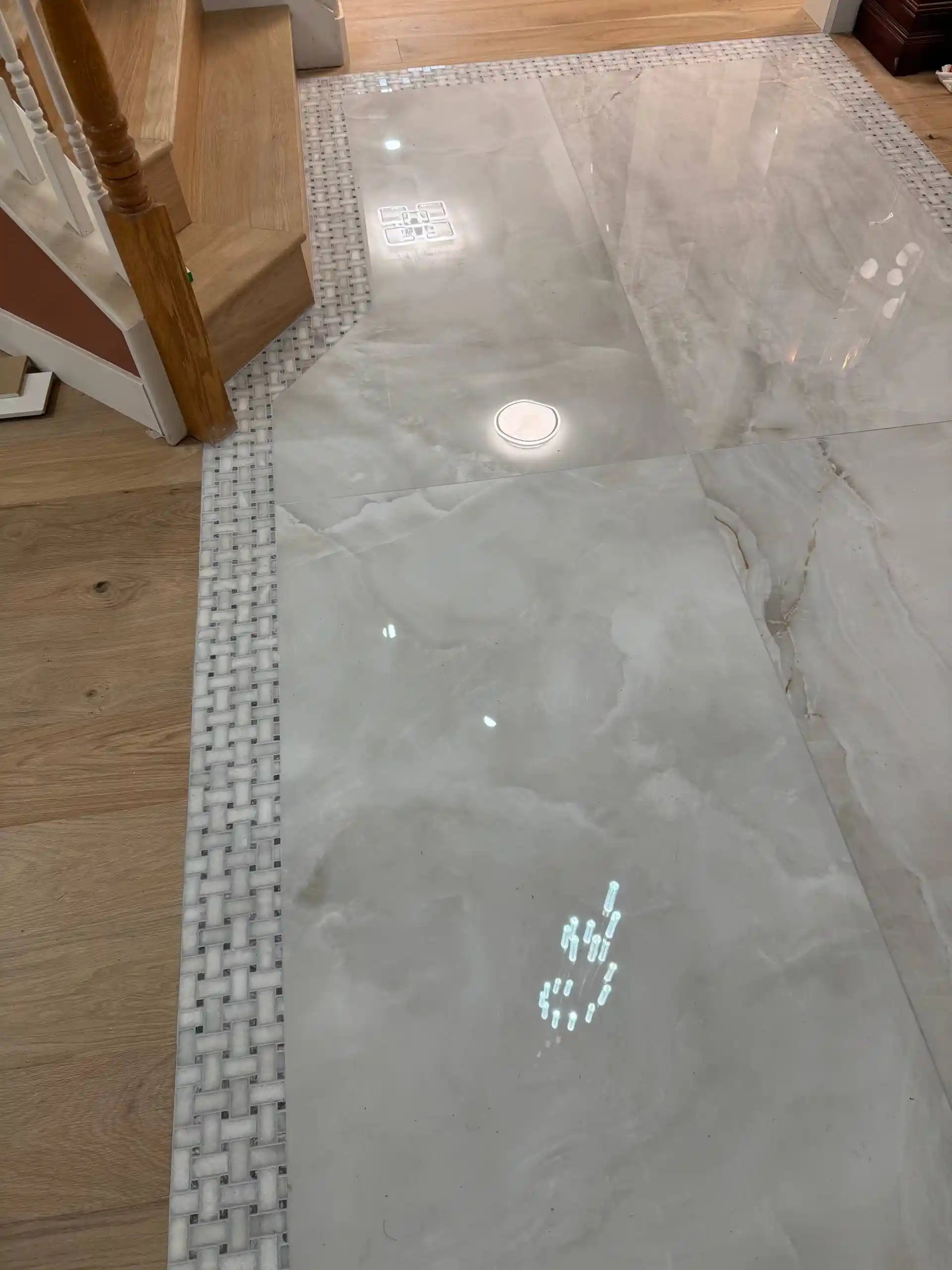 Walk-in shower remodel in Elk Grove with marble-look wall tile, sliding glass door, rainfall shower head, and built-in storage.