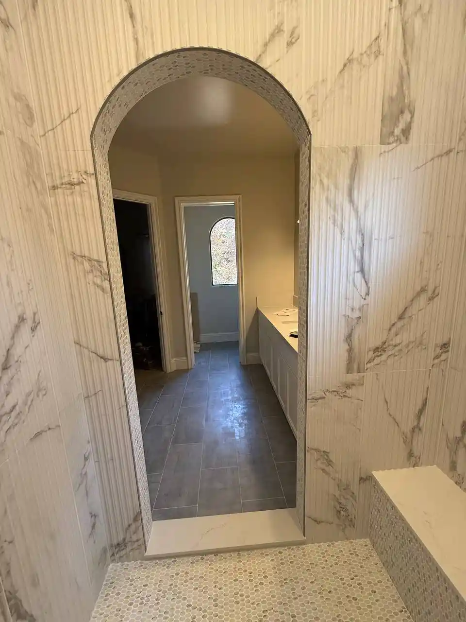 Bathroom remodel installation in Sacramento with new shower walls, vanity, flooring, and fixture updates in progress.