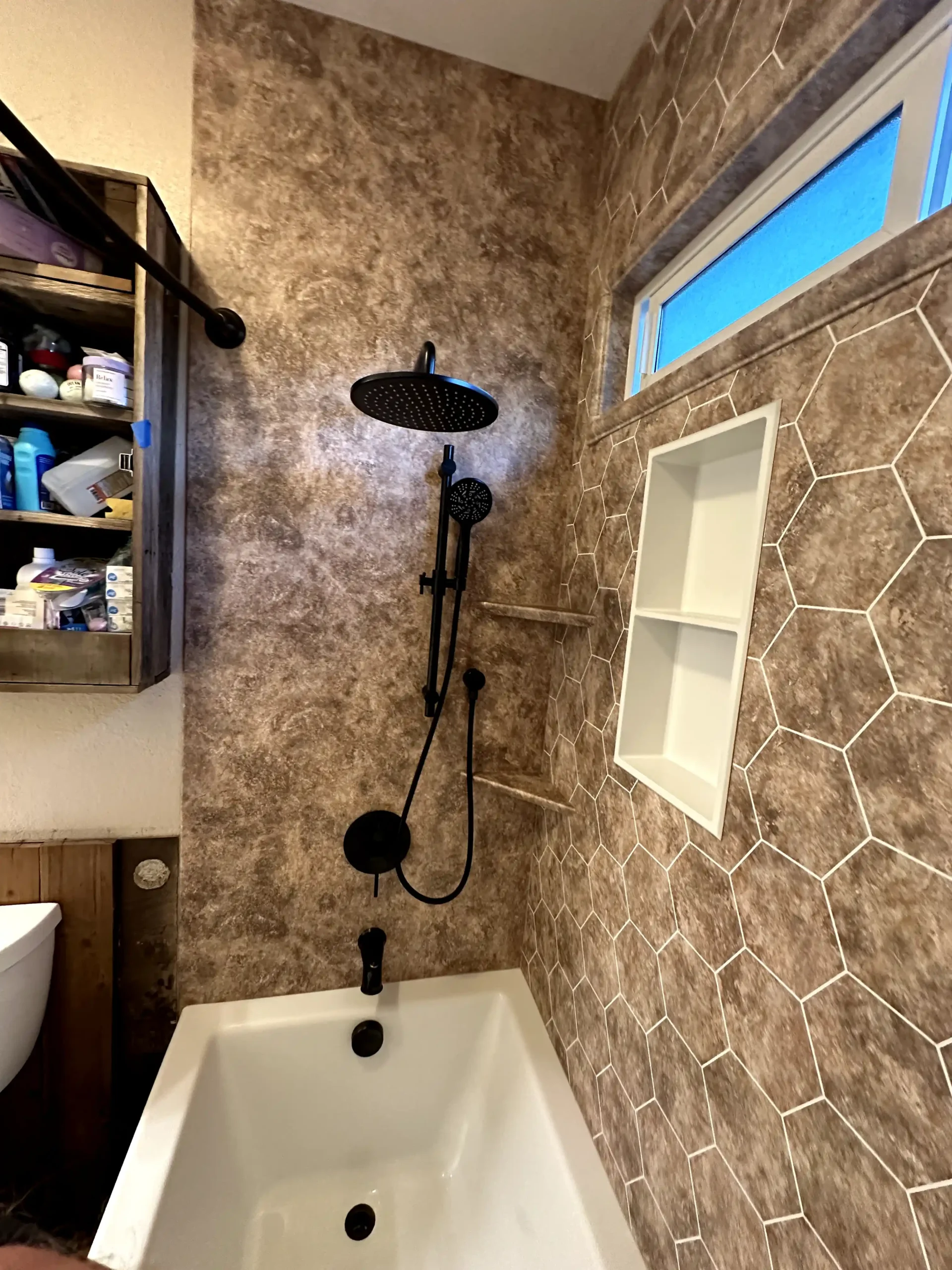 Guest bathroom remodel in El Dorado Hills with white vanity, marble-look floor tile, arched shower opening, blue accent tile, and bathtub.