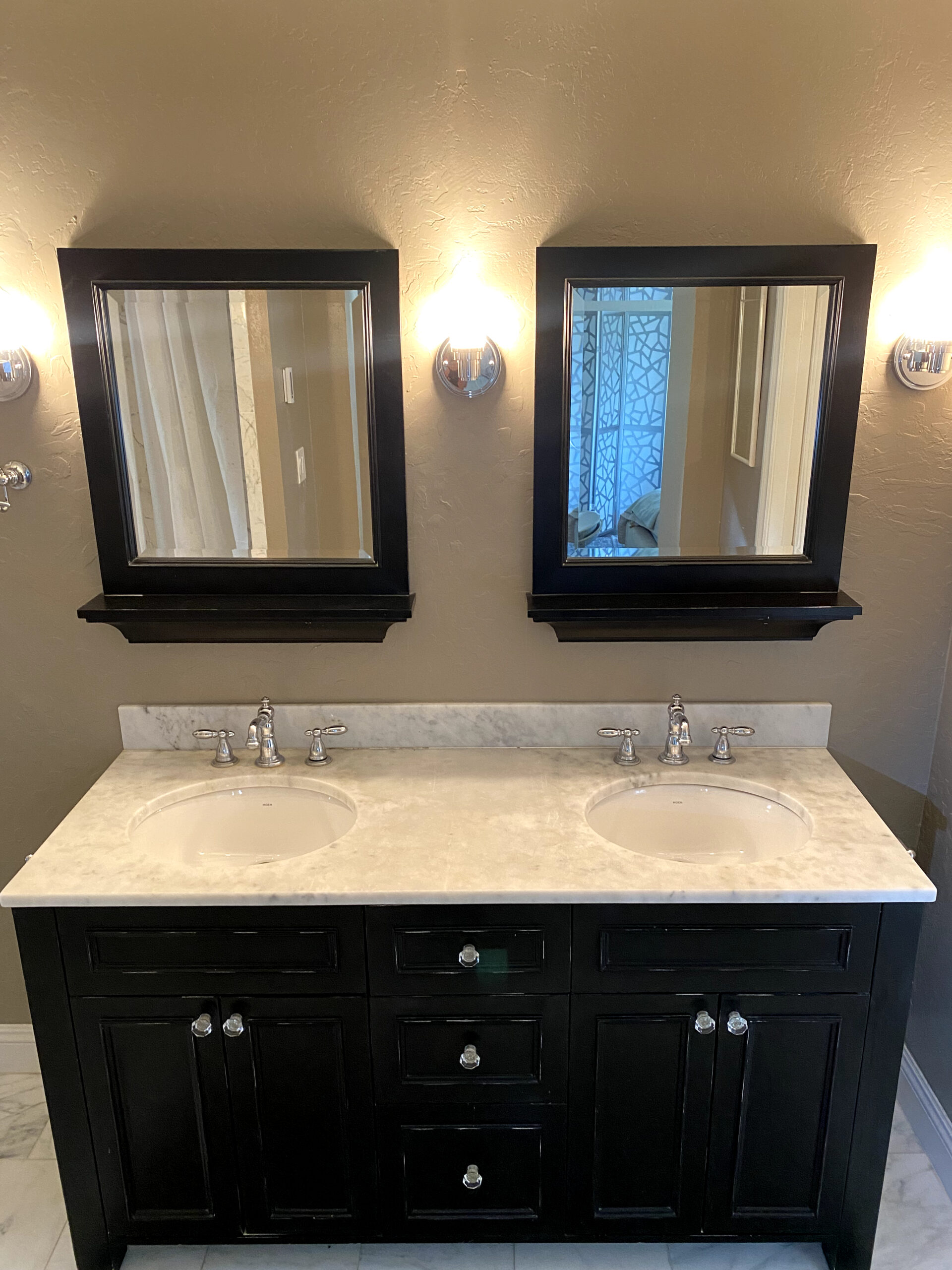 Walk-in shower remodel in Elk Grove with marble-look wall tile, sliding glass door, rainfall shower head, and built-in storage.